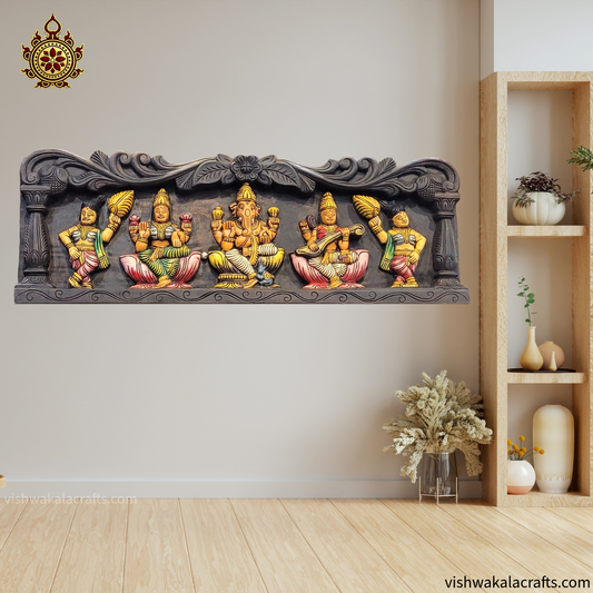 Decorative wall art with colorful figures on a plain wall with a wooden shelf.